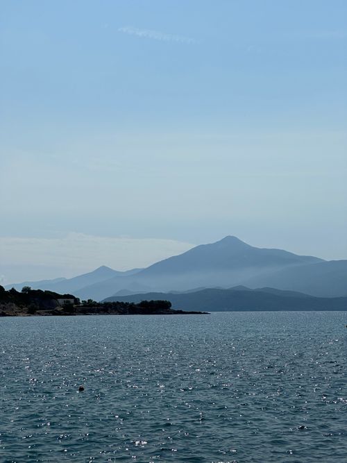 Free Tranquil ocean view with misty mountains in Samos, Greece under clear sky. Stock Photo