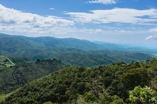 Free A breathtaking aerial view of a lush green mountain range on a clear day. Stock Photo