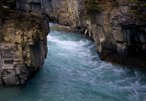 Picturesque river flowing through rocky cliffs in Banff National Park, capturing nature's raw beauty.