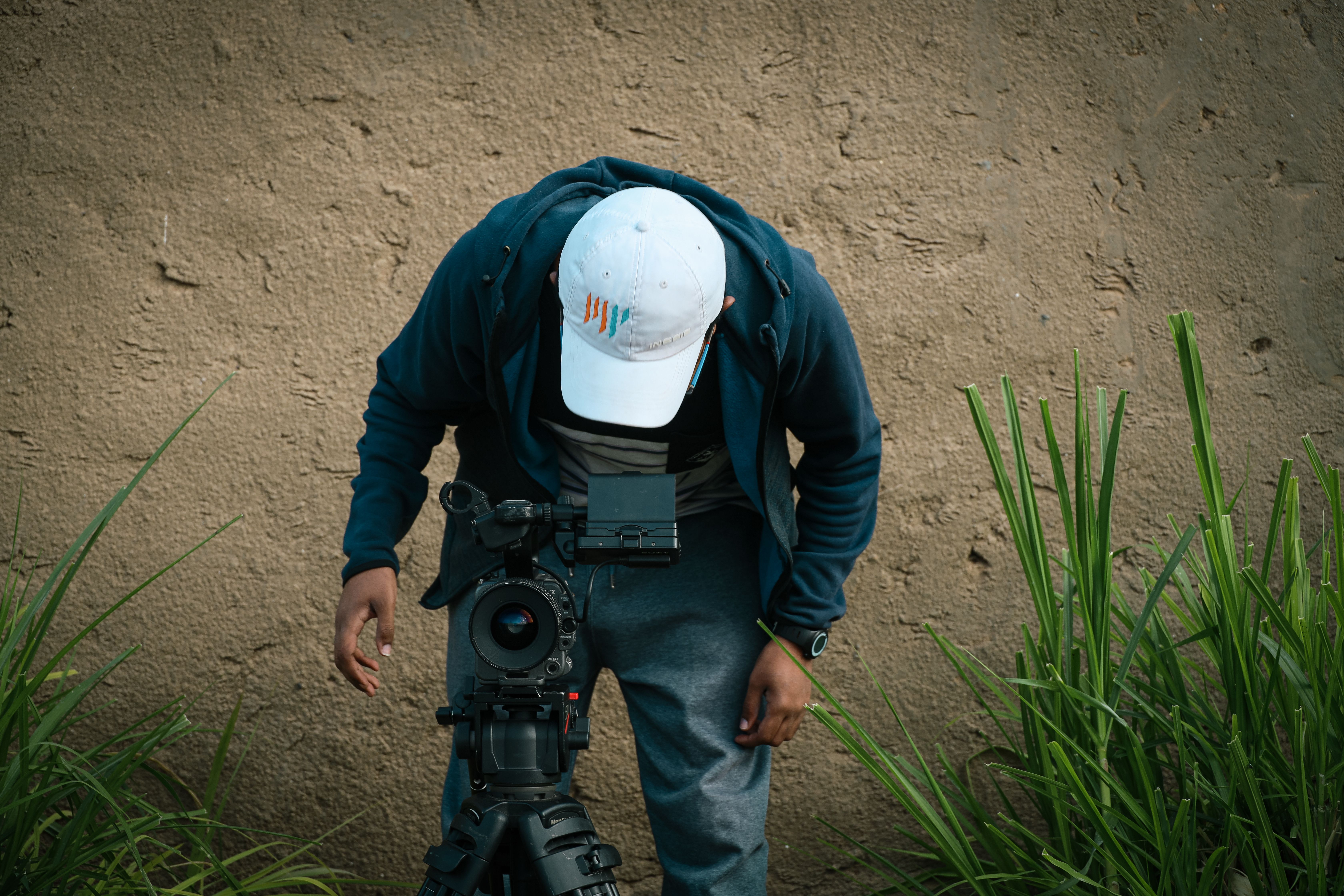 Man in Cap Standing with Camera · Free Stock Photo