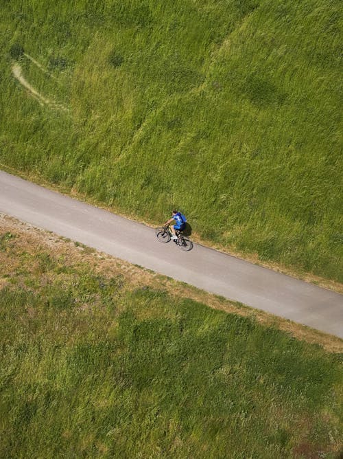 A Man Riding a Bicycle on the Road