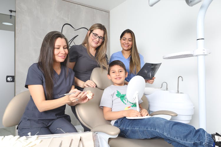 Smiling Women Posing With Boy At Dentist