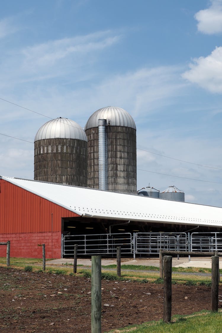 Paddock With A Barn And Two Silos In The Background