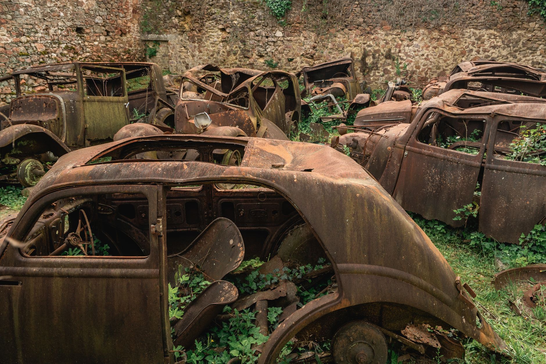 Rusty vintage cars decaying in Oradour-sur-Glane, France, a poignant reminder of history.