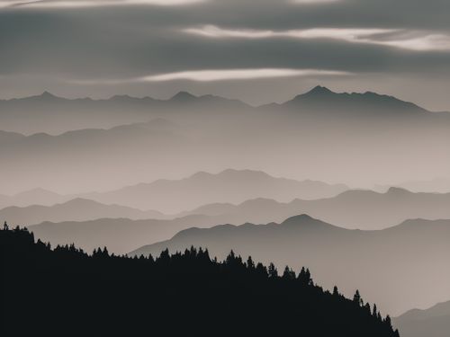 Free Serene mountain landscape with layers of fog and mist creating a mysterious atmosphere. Stock Photo