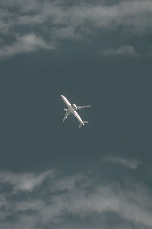 Free Aerial view of a passenger airplane flying through dense clouds in the sky Stock Photo