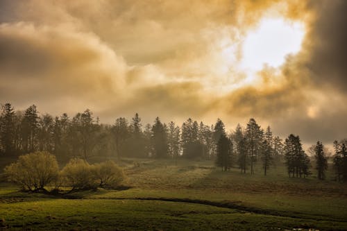 Sun Shinning behind Clouds over Rural Landscape