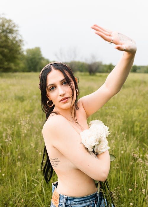 Topless Woman Holding a Bunch of Flowers on a Meadow 