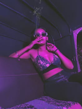 Young woman smoking in a trendy purple-lit auto rickshaw, exuding a cool, modern vibe.