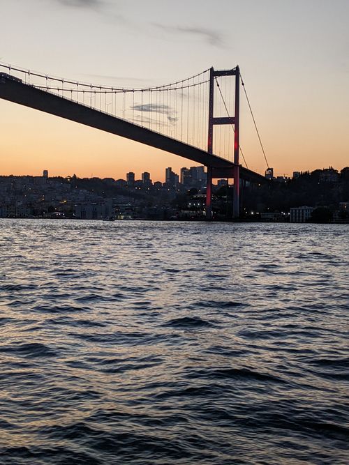 Free Scenic view of the Bosphorus Bridge at sunset capturing the vibrant Istanbul skyline and tranquil waters. Stock Photo