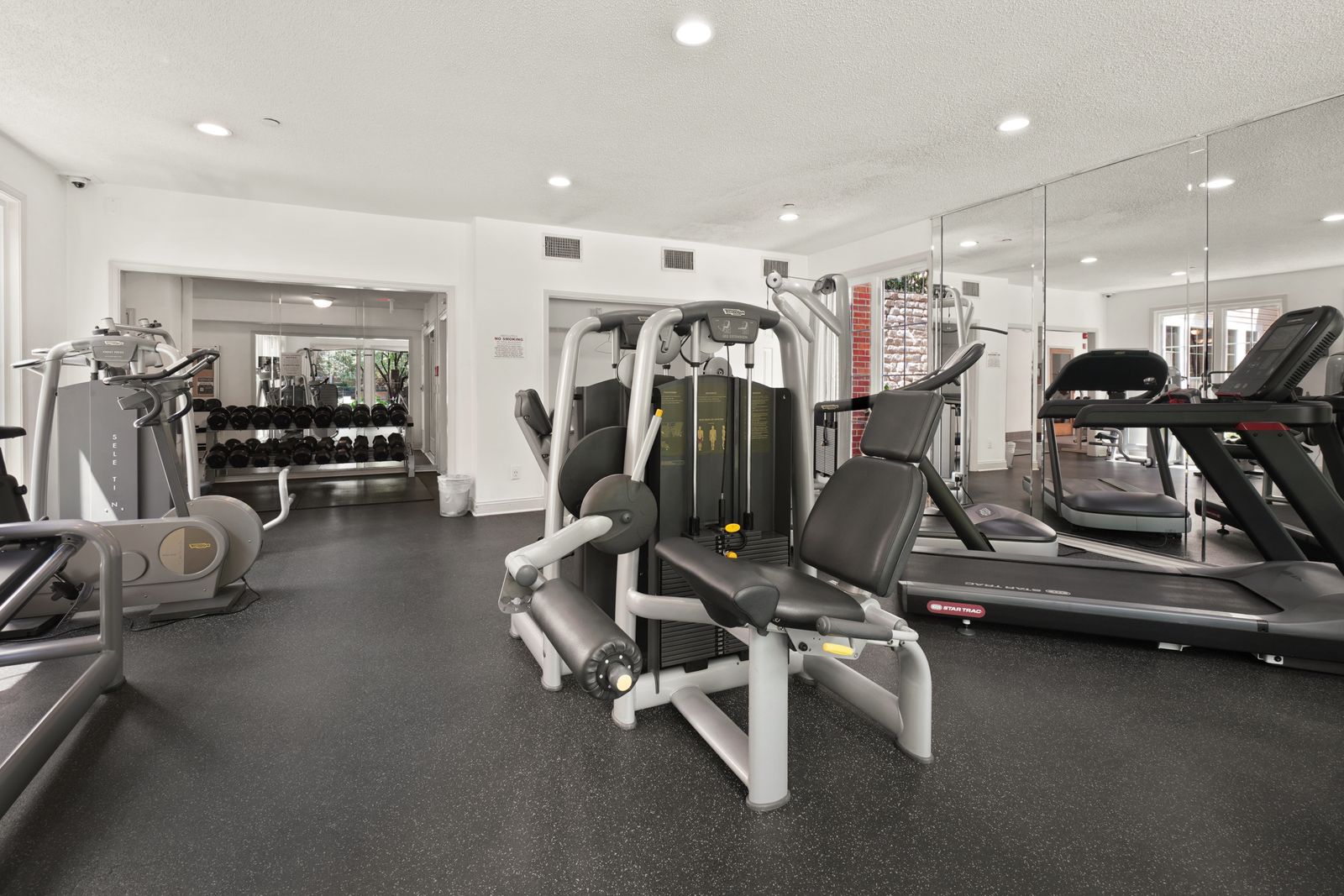 The inside of a gym with equipment along the wall