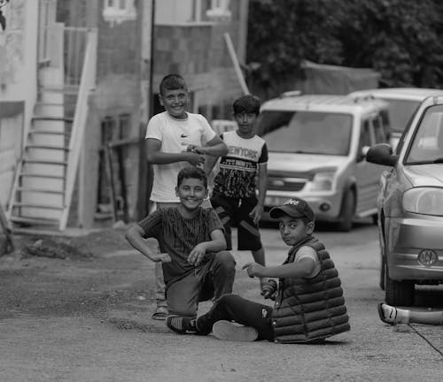 Free Smiling Boys Playing on Street in Black and White Stock Photo