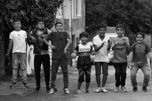 Free A black and white photo of cheerful boys posing and smiling on a city street. Stock Photo