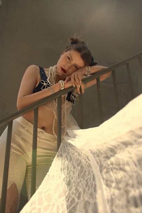 Free Artistic portrait of a fashionable woman posing on a staircase with pearls. Stock Photo