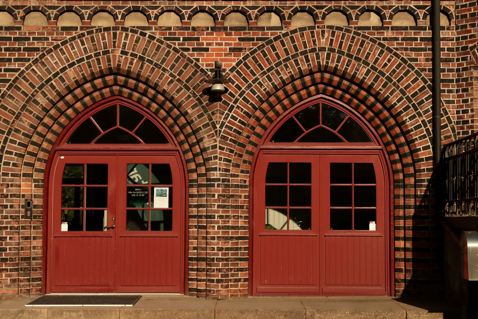 Sunlit double doors on a vintage brick building in Jönköping, Sweden.