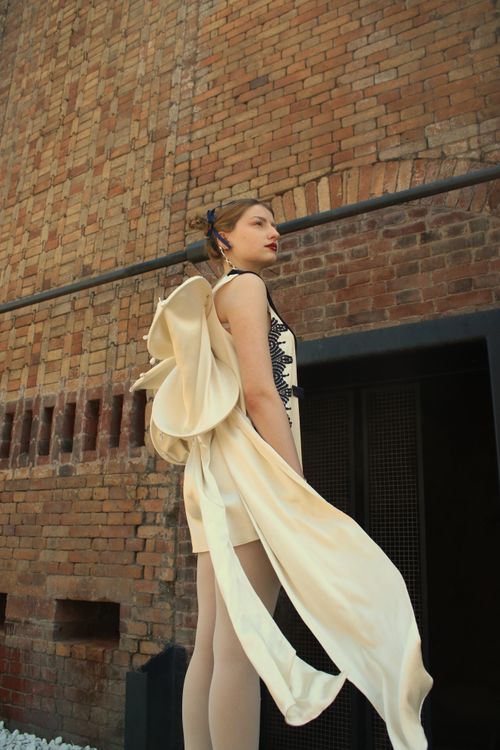 Free Stylish woman posing in an elegant outfit with urban brick wall backdrop. Stock Photo