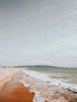 Sunny day at Manhattan Beach, CA with waves hitting the sandy shore.