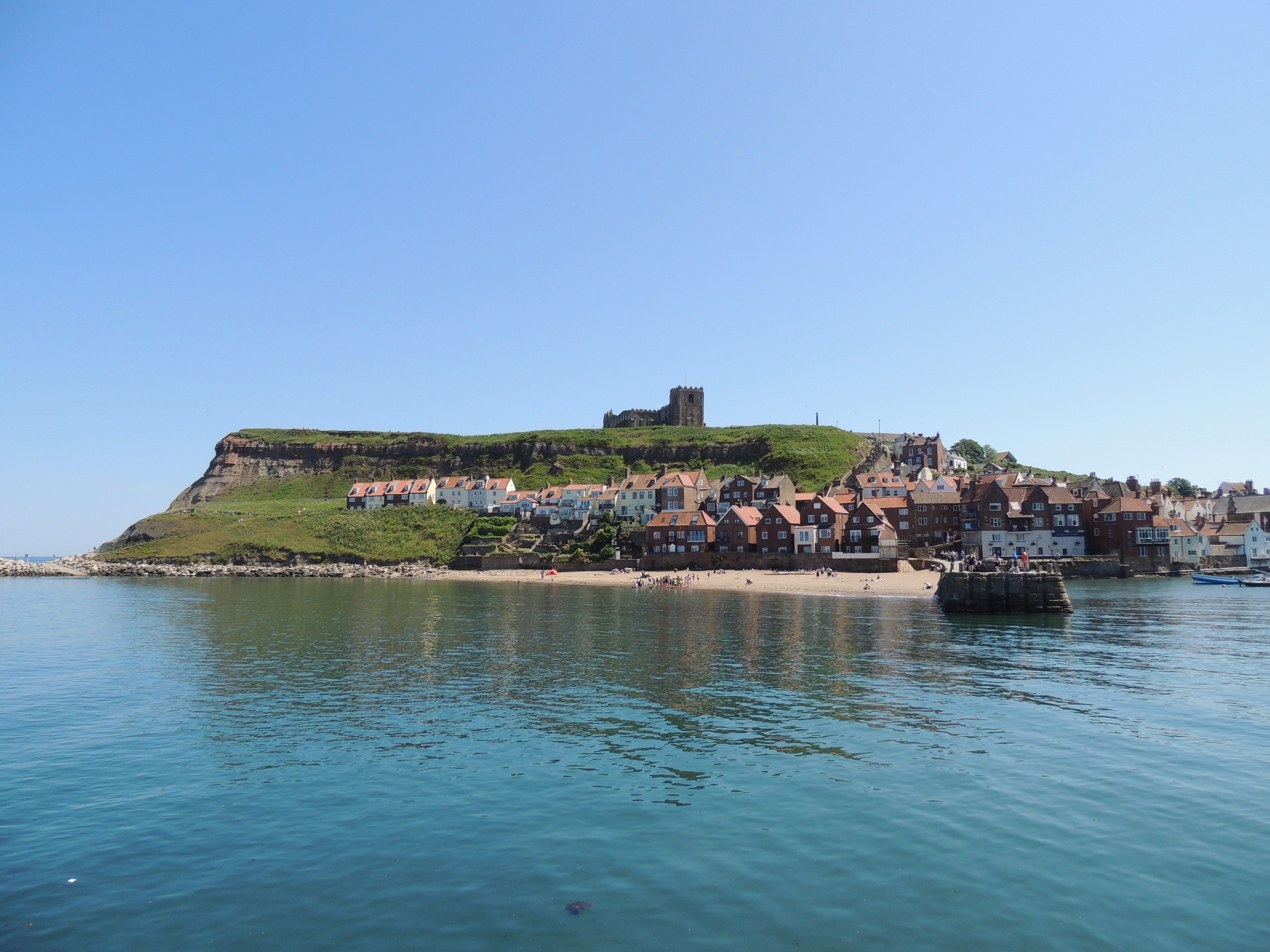 Tate Hill Sands and the East Cliff from the water, cottages clustered beneath St Mary's church.