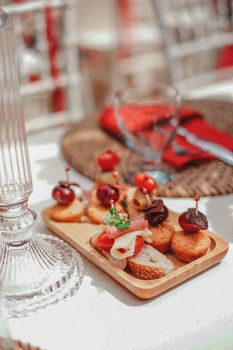 A beautifully set restaurant table with a wooden tray of appetizers and elegant glassware.