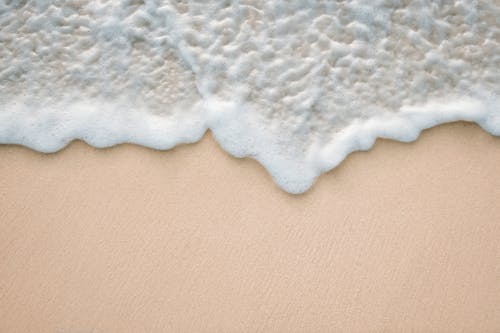 Sand and Water Foam on Shore