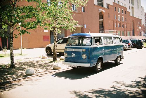 Free A classic blue Volkswagen van parked on a sunny street in an urban setting. Stock Photo