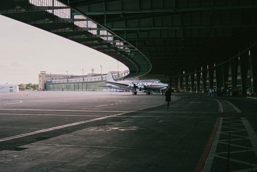 A classic aircraft parked inside an iconic Berlin hangar, showcasing aviation history.