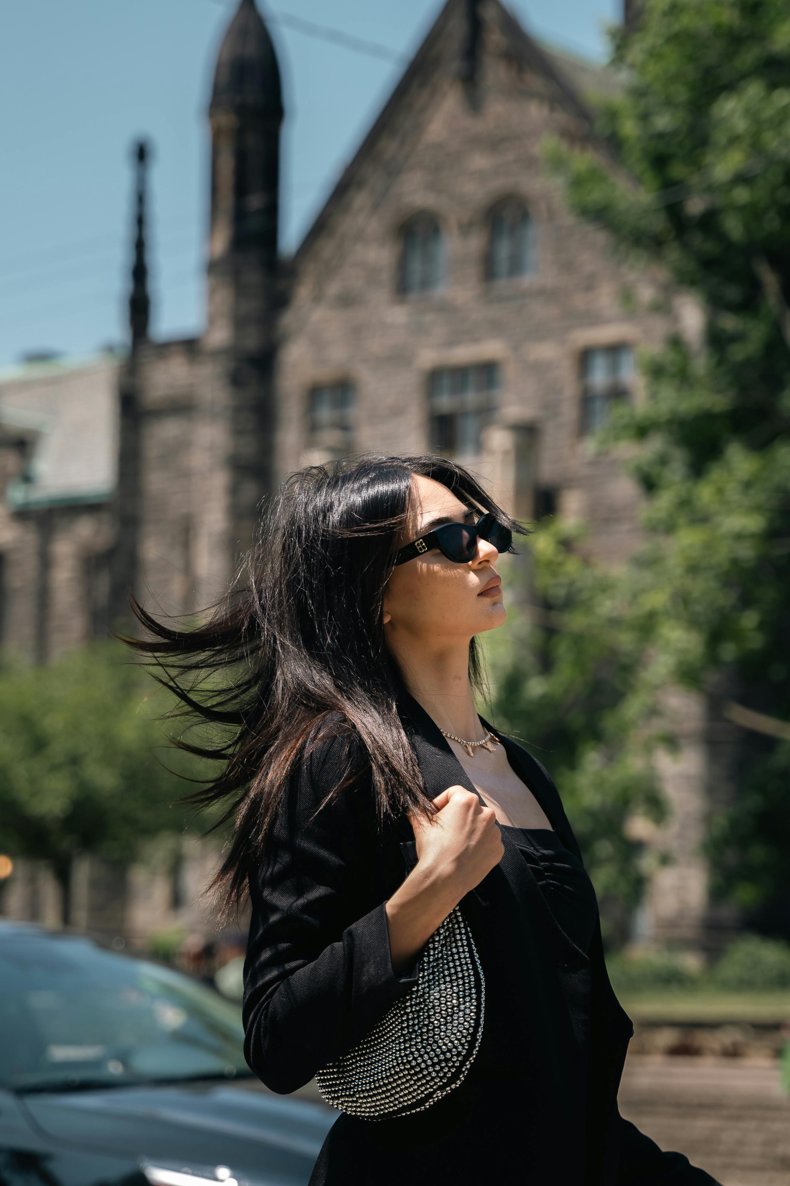 woman posing in sunglasses and with bag