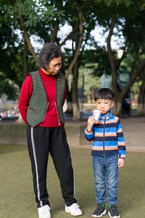 Toddler Boy Standing Beside Woman