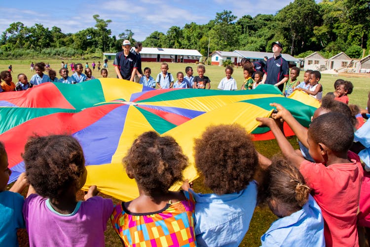 Children Playing With Multi Colored Giant Cloth