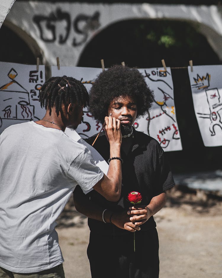 Man Painting Other Man Face With Paintbrush