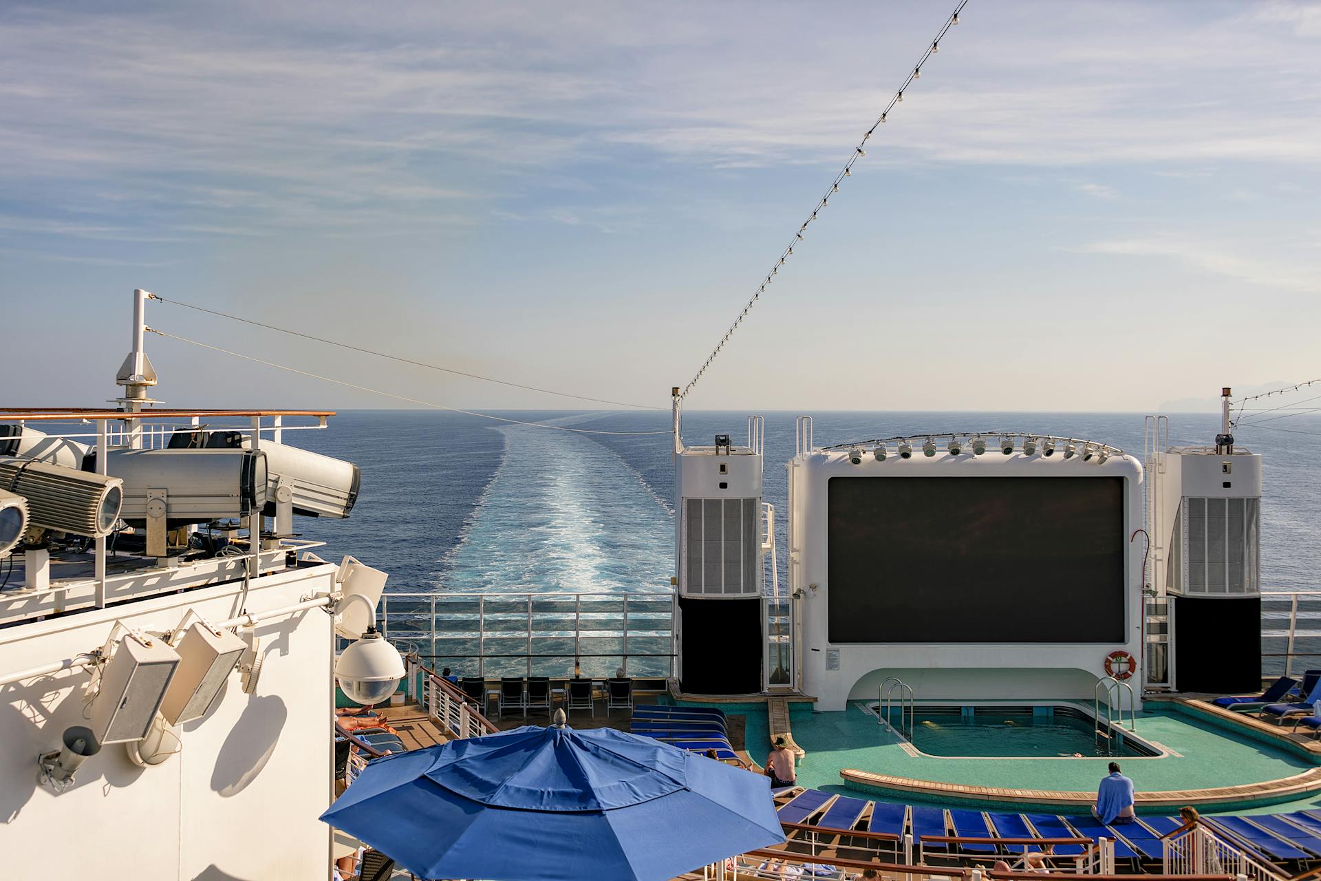 View of a cruise deck featuring a pool and large screen overlooking the open sea.