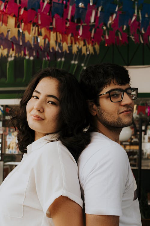 Free Young Romantic Couple Standing Back to Back Stock Photo