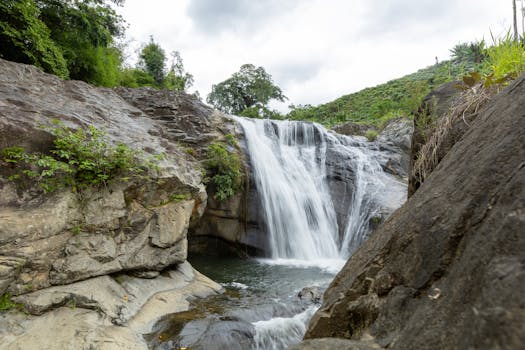 A beautiful waterfall cascading over rocks in a lush, tropical setting.