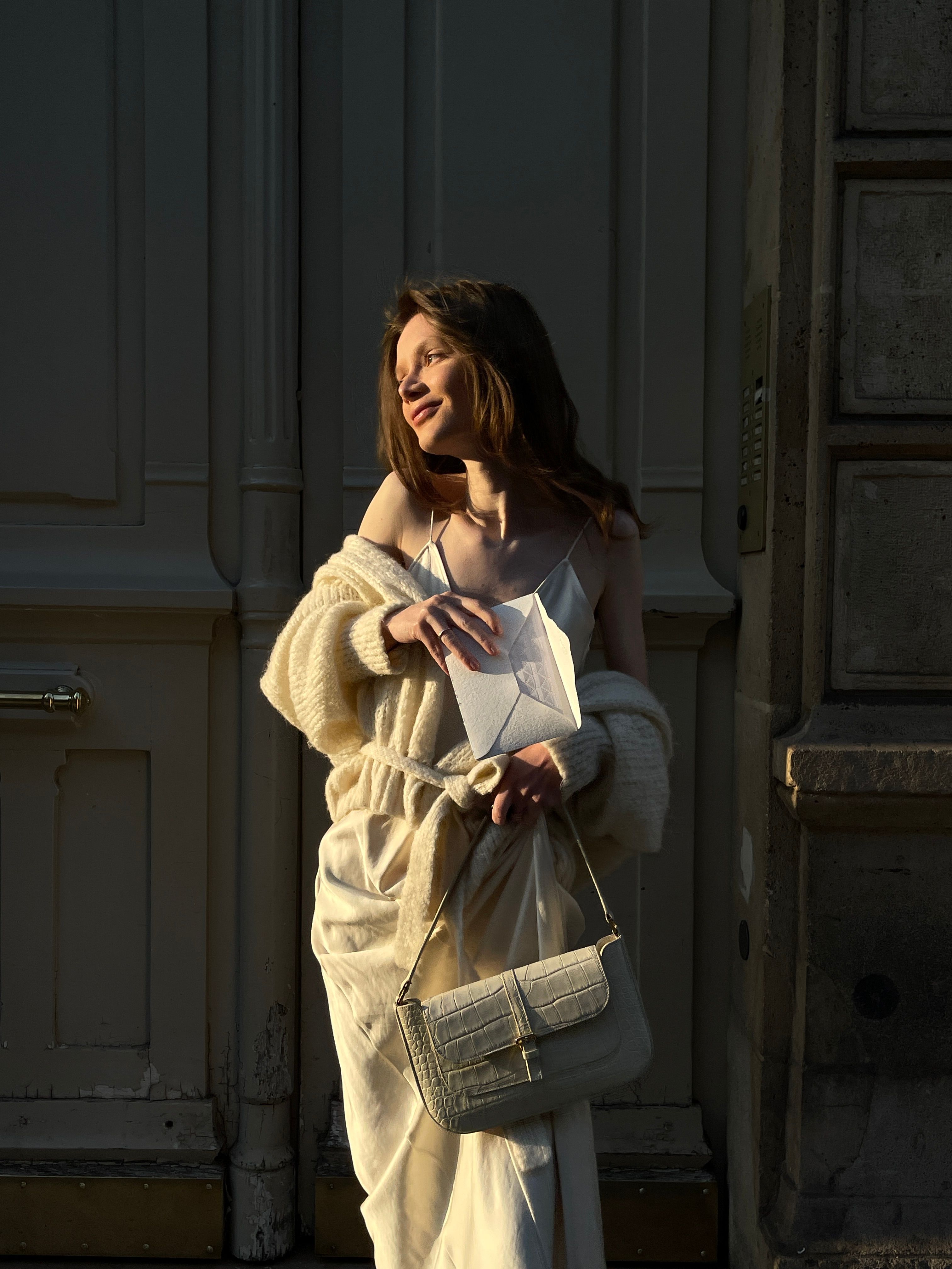 Woman layering an oversized cardigan over a slip dress