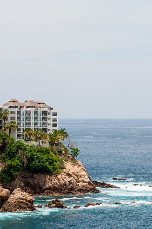 Free Resort perched on rocky cliffs with ocean view in Acapulco, Mexico. Stock Photo