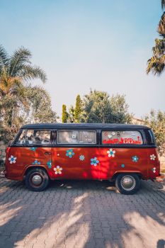 Retro van with floral decorations parked outdoors on a sunny day.