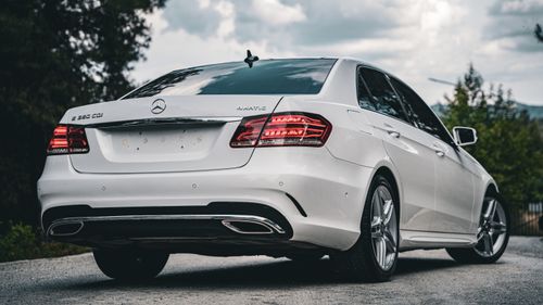 Free Elegant white Mercedes-Benz E-Class parked outdoors showcasing luxury and sophistication. Stock Photo