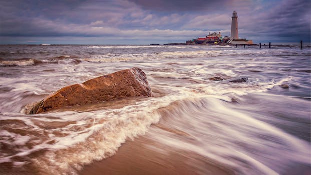 Dynamic view of waves crashing on rocks near St Mary's Lighthouse at Whitley Bay.