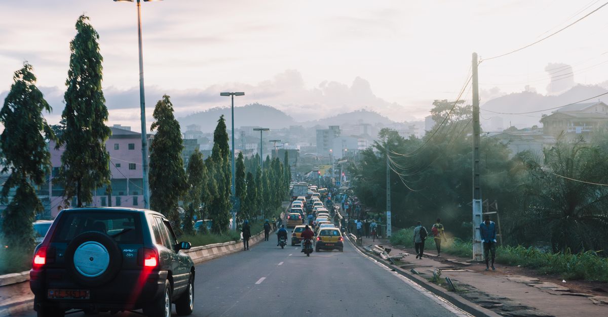 Viajera consultando el móvil con una eSIM para Camerún en una calle de Yaundé