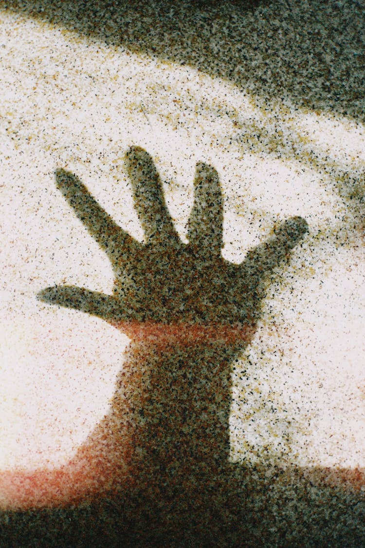 Close-up Of Person Hand Shadow On Ground