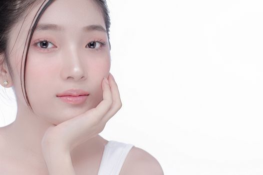 Close-up portrait of a young woman with clear skin in a studio setting, showcasing beauty and skincare.