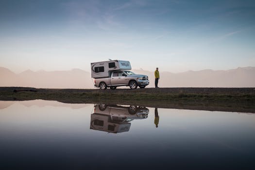 Discover tranquility with a camper van by a reflective lake in Iceland's serene landscape.