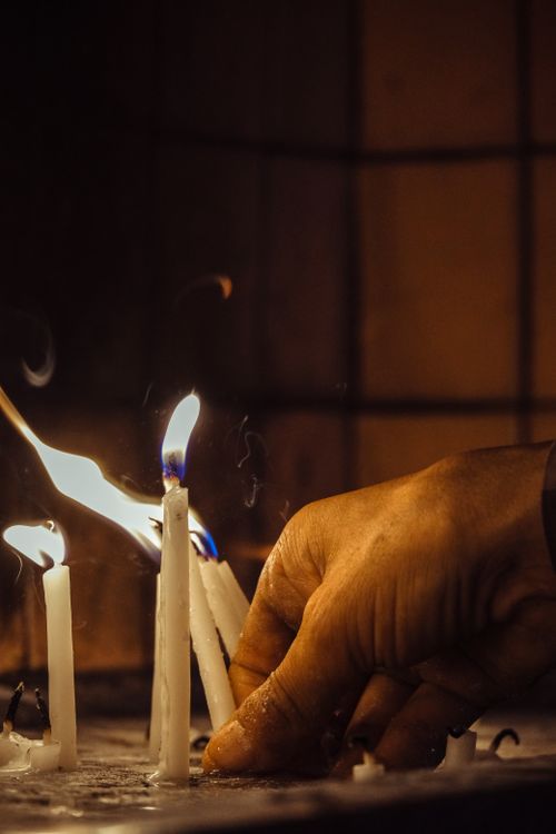 Free Close-up of a hand lighting candles, creating a warm and intimate atmosphere. Stock Photo