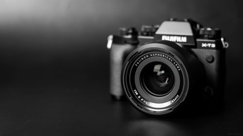 Free High-contrast black and white photo of a Fujifilm camera with lens. Stock Photo