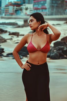 Stylish portrait of a woman posing by the seaside, showcasing summer fashion.