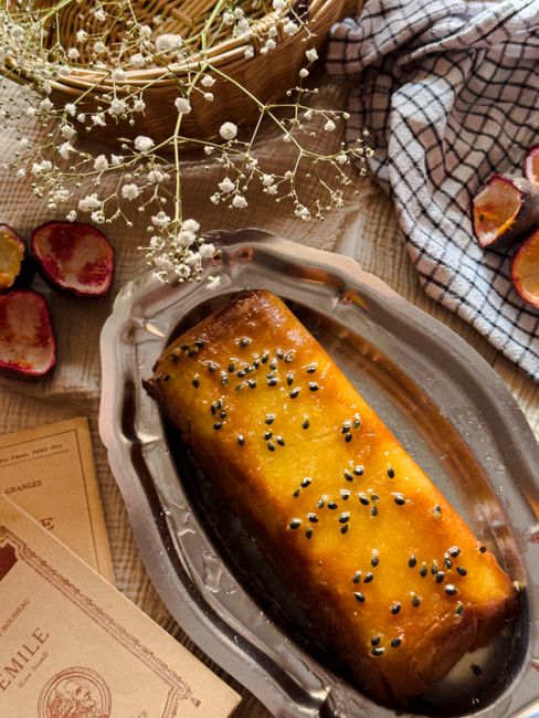 Delicious homemade passion fruit cake on a rustic tray surrounded by floral decor.