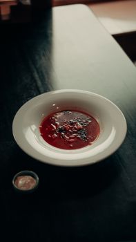 A beautifully plated bowl of gourmet tomato soup on a dark table, perfect for a warm meal.