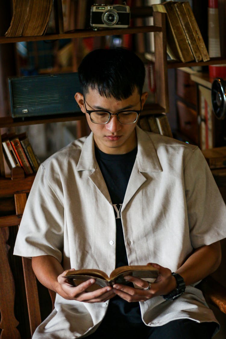 Man In Shirt Sitting And Reading Book