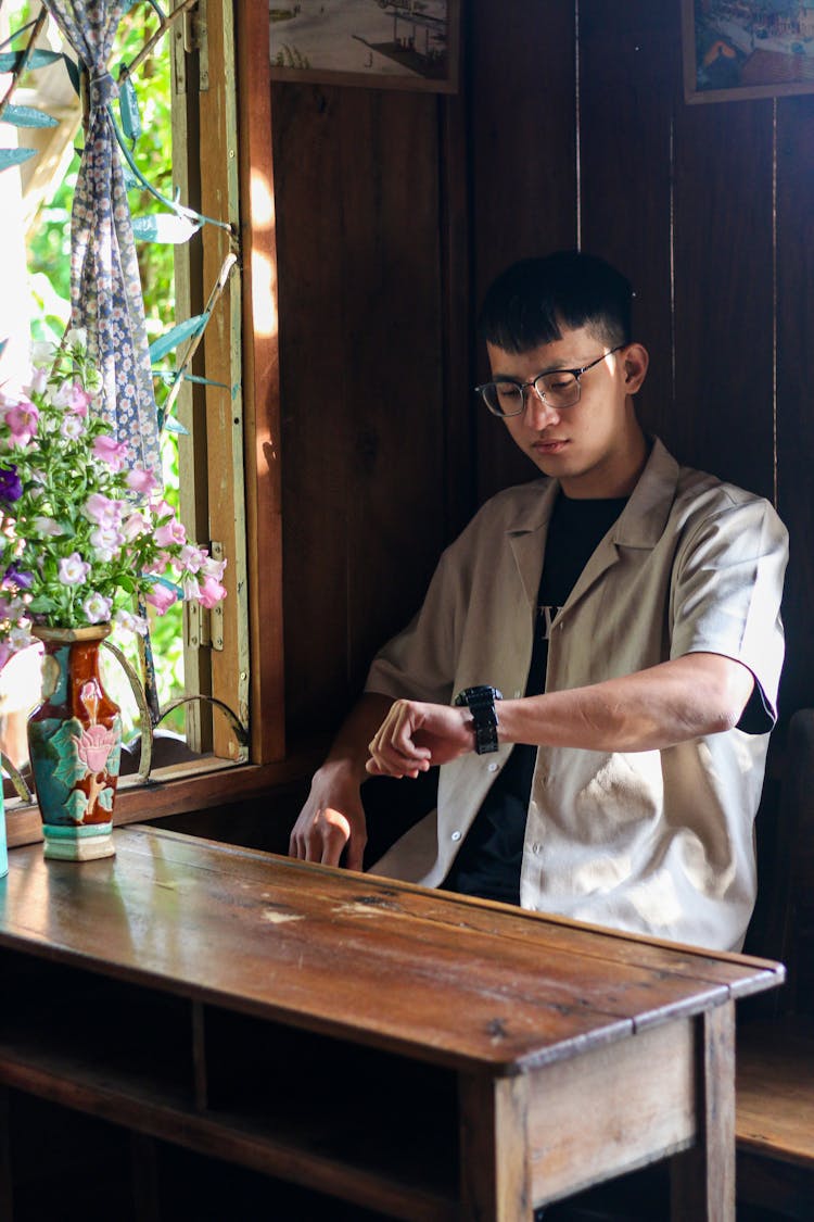 Man In Eyeglasses Sitting And Checking Time