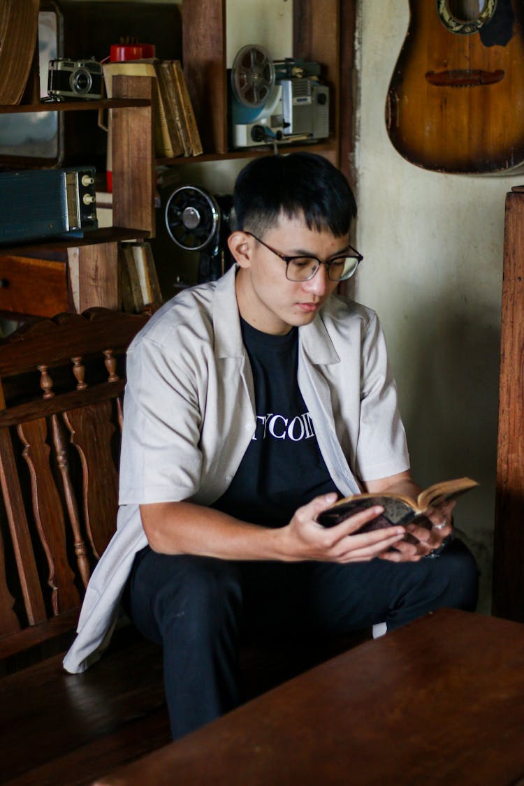 Man In Shirt Sitting And Reading Book